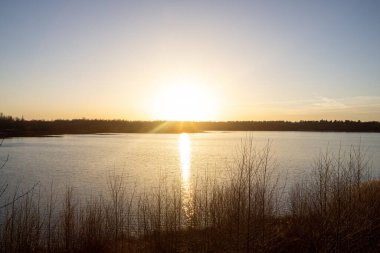 Orman gölünün üzerinde dramatik bir gün batımı