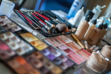 Profesyonel makyözler üzerinde çeşitli kozmetik ürünleri olan masalarda çalışırlar..