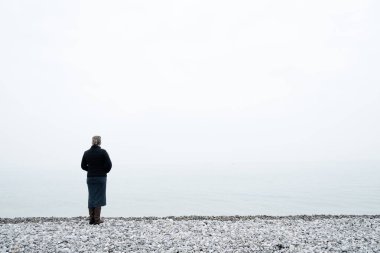 Sisli denize bakan bir kadın