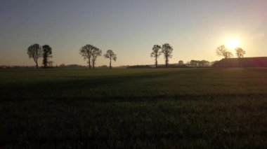 Hava sineması klibi, hava aracı gün batımında bir çiftlik arazisinde uçuyor.