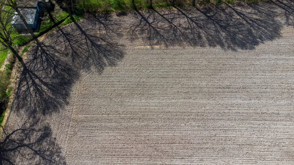 Flygfoto geometriska odlingsfält, visar en grön äng och plogade fält, fångas med en drönare — Stockfoto