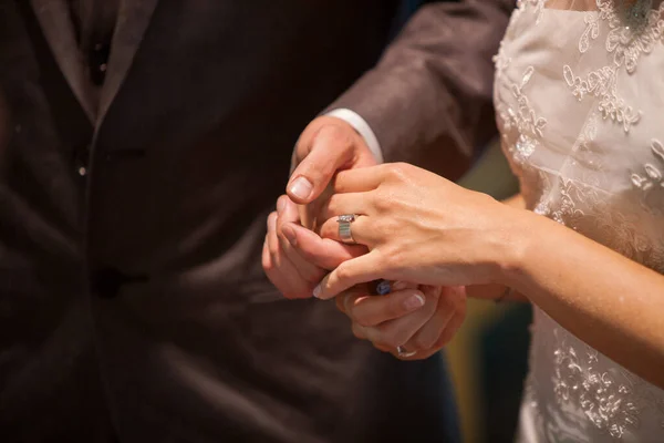 Fechar-se de noiva colocando um anel de casamento no dedo do noivo. Casal trocando alianças. — Fotografia de Stock