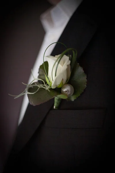 Le marié en costume redresse sa cravate. Boutonnière sur le revers de la veste. jeune homme en costume d'affaires. Un homme en costume sombre, détail gros plan. — Photo