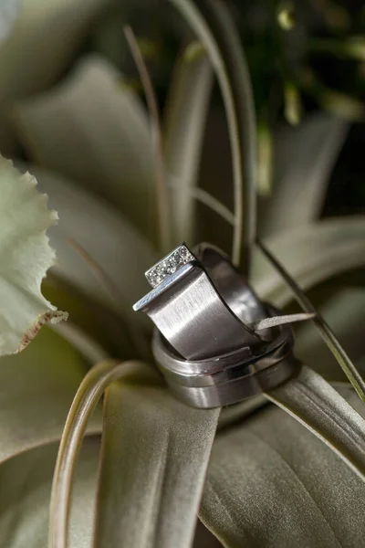 Vista de perto das alianças de casamento de prata e um lindo buquê de casamento nupcial, close-up. — Fotografia de Stock