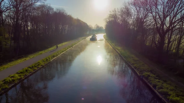 Légi kilátás egy idilli folyómeder csatorna egy hajó vagy hajó a távolban egy festői táj egy ködös napsütéses tavaszi reggeli napkelte napján, vett egy drón — Stock Fotó