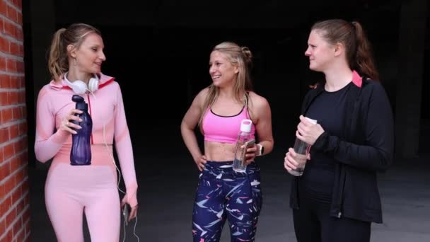Lebensstil, Freundinnen plaudern nach dem gemeinsamen Laufen oder Sport in der Stadt, reden lächelnd und trinken Wasser — Stockvideo
