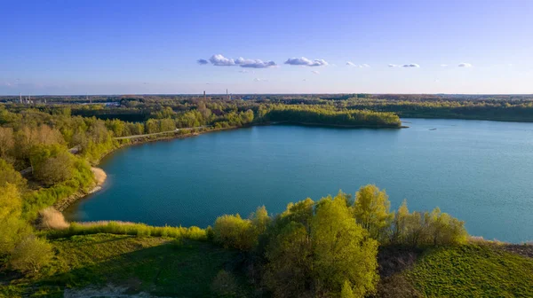 Bahar zamanı Beerse, Belçika 'da gün batımında orman gölü üzerinde hava manzarası çok güzeldir.