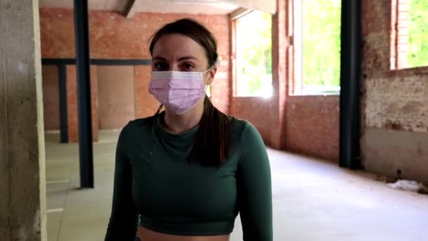 Styl życia portret atrakcyjnej młodej kobiety w sportowej odzieży w środowisku miejskim zdejmującej maskę twarzy dla jej zdrowia, aby chronić się przed Corona lub Covid — Wideo stockowe