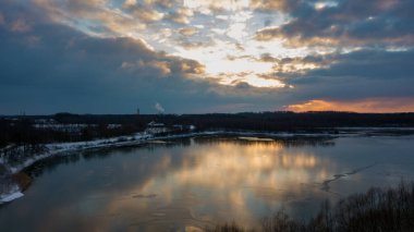 Bir orman gölü üzerinde güzel ve dramatik bir gün batımının havadan görüntüsü suya yansıyor, insansız hava aracı görüntüleri.