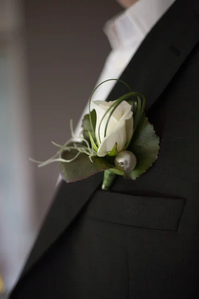 Le marié en costume redresse sa cravate. Boutonnière sur le revers de la veste. jeune homme en costume d'affaires. Un homme en costume sombre, détail gros plan. — Photo