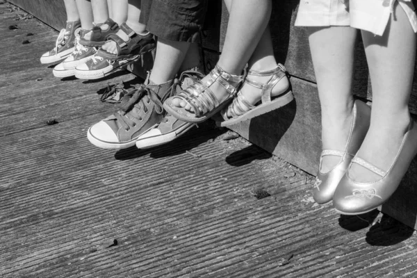 Ryhmä onnellisia lapsia jalat ja jalat, sekä pojat että tytöt mustavalkoisina — kuvapankkivalokuva