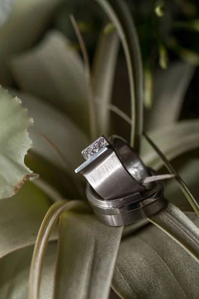 Vista de perto das alianças de casamento de prata e um lindo buquê de casamento nupcial, close-up. — Fotografia de Stock