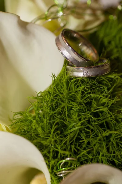 Close view on calla flowers with wedding rings in warm colors — Stock Photo, Image