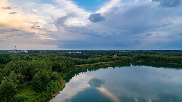 Vista aérea de um pôr do sol bonito e dramático sobre um lago de floresta refletido na água, paisagem drone tiro — Fotografia de Stock