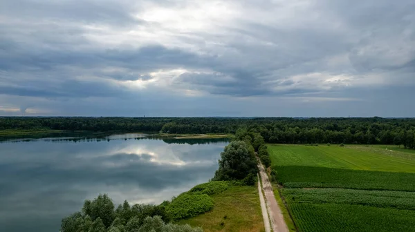 Vista aérea de um pôr do sol bonito e dramático sobre um lago de floresta refletido na água, paisagem drone tiro — Fotografia de Stock