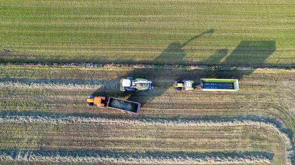 Aérien de la presse à balles tracteur faisant des balles de paille dans le champ après la récolte de blé en été à la ferme — Photo