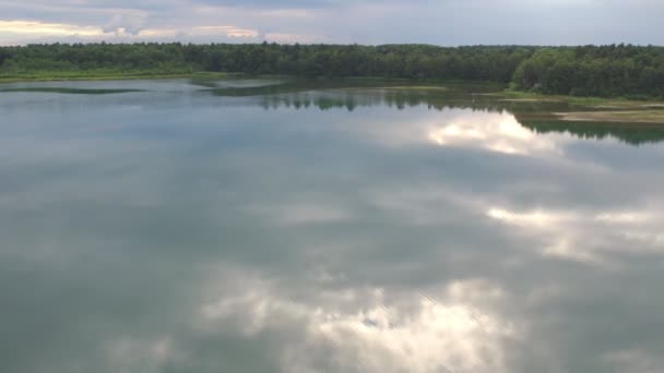 Vågigt vatten yta med suddig himmel reflektion. Rippad vattenstruktur med suddig reflektion i starkt solljus. Lugnt landskap med skogssjö — Stockvideo