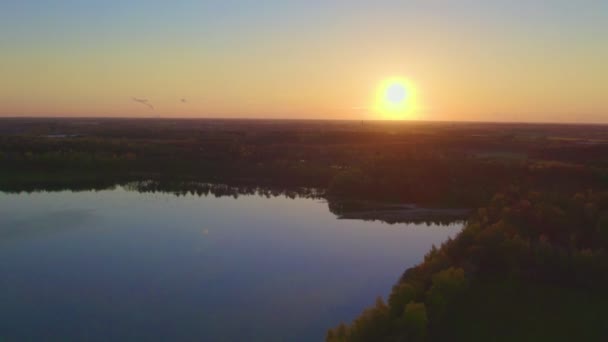 Prachtige luchtfoto gemaakt met drone landschap met zonsondergang boven het grote meer en de landbouwgrond en het bos. — Stockvideo