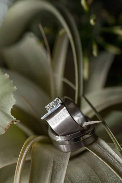 Vista de perto das alianças de casamento de prata e um lindo buquê de casamento nupcial, close-up. — Fotografia de Stock