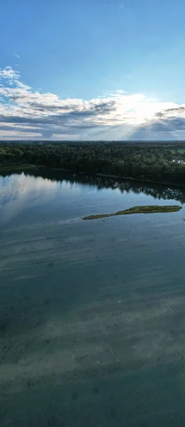 Vista panorámica aérea de una hermosa y dramática puesta de sol sobre un lago forestal reflejado en el agua, paisaje drone shot — Foto de Stock