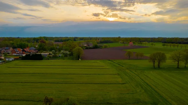 Foto aérea de campos agrícolas con hermosa puesta de sol con rayos de sol tomados con un dron —  Fotos de Stock