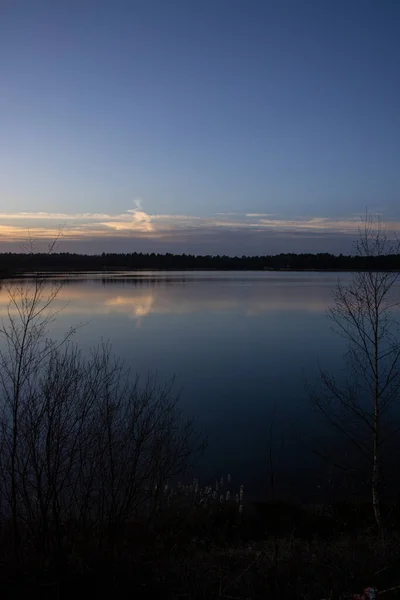 Драматический закат над лесным озером — стоковое фото