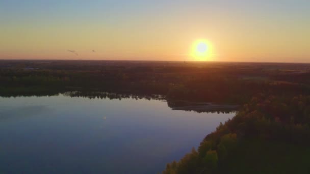 Prachtige luchtfoto gemaakt met drone landschap met zonsondergang boven het grote meer en de landbouwgrond en het bos. — Stockvideo