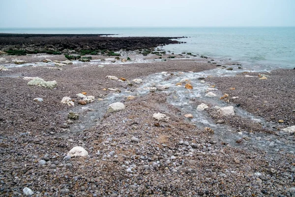 Fale myjące się nad skałami w oceanie na plaży w Normandii, Francja — Zdjęcie stockowe