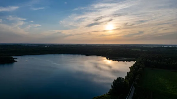 Vista aérea filmada por um drone de um belo pôr do sol dramático e colorido na costa do lago. Natureza paisagem. Natureza na Europa. reflexão, céu azul e luz solar amarela. paisagem durante o nascer do sol ou — Fotografia de Stock