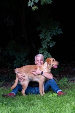 Yakışıklı kadın arka bahçede Mutlu Altın Labrador Köpeği 'yle oynuyor. 