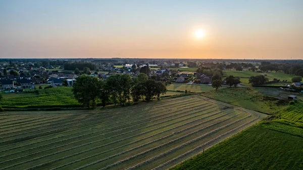 Vista aérea con un dron de un paisaje rural agrícola ondulado de primavera con campos y árboles arados y sin arar en el cielo azul de la noche —  Fotos de Stock