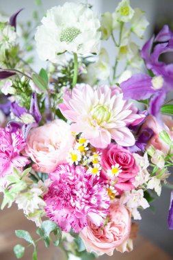 Güzel bir çiçek kompozisyonu. Beyaz bir kağıt ve büyük, gür şakayık desenli bir maket. Yaz mahsulü dekor. Ahşap bir masa üzerinde yerleşim.