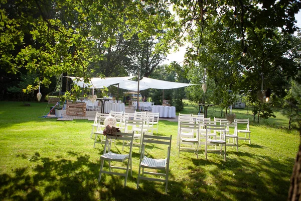 Sillas de boda, establecidas en filas fuera en el parque, con decoraciones hechas a mano —  Fotos de Stock