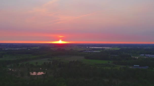 Platteland dramatische en kleurrijke zonsondergang vlucht over een bos meer, luchtfoto op een drone — Stockvideo