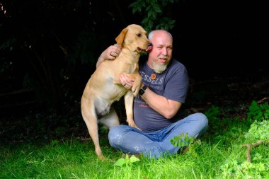 Yakışıklı Adam Arka Bahçe Bahçesinde Mutlu Altın Labrador Köpeği ile oynuyor. Erkek Sadık Pedigree Köpeğiyle Eğlendi Yazlık Ev Bahçesi 'nde.