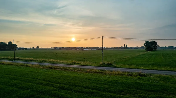 Colorido amanecer rural sobre los campos agrarios mostrando los colores dramáticos y las nubes en el cielo —  Fotos de Stock