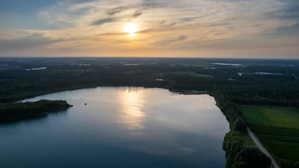 Pemandangan udara ditembak oleh drone dari indah dramatis dan warna-warni matahari terbenam di pantai danau. Alam lansekap. Alam di Eropa. Pantulan, langit biru dan sinar matahari kuning. lanskap selama matahari terbit atau — Stok Foto