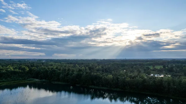 Pandangan udara tentang matahari terbenam yang indah dan dramatis di atas sebuah danau hutan yang tercermin dalam air, foto drone di permukaan laut — Stok Foto
