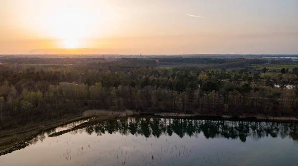 Vista aérea filmada por um drone de um belo pôr do sol dramático e colorido na costa do lago. Natureza paisagem. Natureza na Europa. reflexão, céu azul e luz solar amarela. paisagem durante o nascer do sol ou — Fotografia de Stock