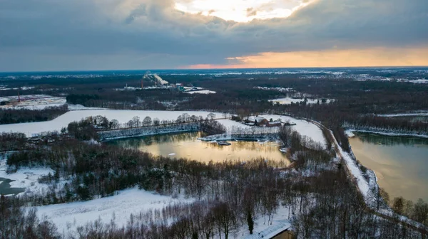 Vista aérea del bosque cubierto de nieve de invierno y el lago congelado desde arriba capturado con un dron — Foto de Stock
