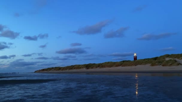 Hoge vuurtoren silhouet tegen zonsondergang hemel. — Stockvideo