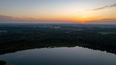 Gün batımında gölün üzerinde güzel, renkli bir gökyüzü. Huzurlu manzara, görünürde kimse yok. 