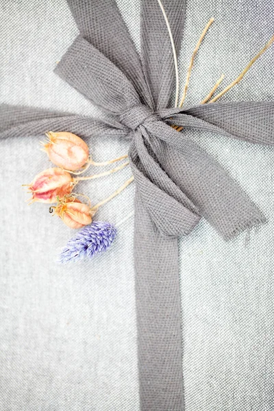 Stäng upp söt grå rosett på en grå linnen förpackning — Stockfoto
