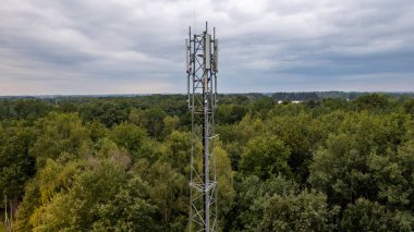 3G, 4G, 5G. Cep telefonu baz istasyonu kulesi. NPN-Kentsel Orman Bölgesi 'nde iletişim sisteminin gelişimi koyu gri gökyüzü arka planına sahip