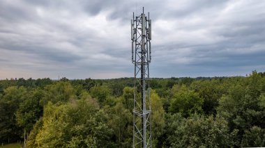 3G, 4G, 5G. Cep telefonu baz istasyonu kulesi. NPN-Kentsel Orman Bölgesi 'nde iletişim sisteminin gelişimi koyu gri gökyüzü arka planına sahip