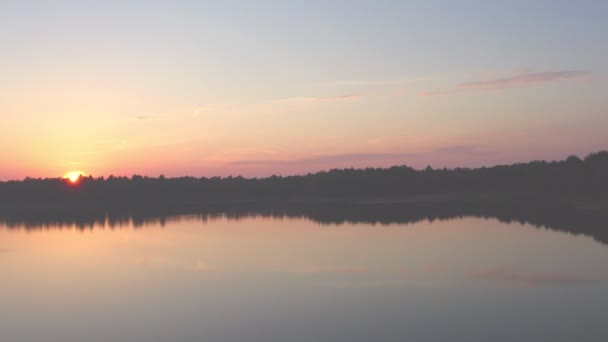 Coucher de soleil spectaculaire et coloré au-dessus d'un lac forestier, prise de vue aérienne sur un drone — Video