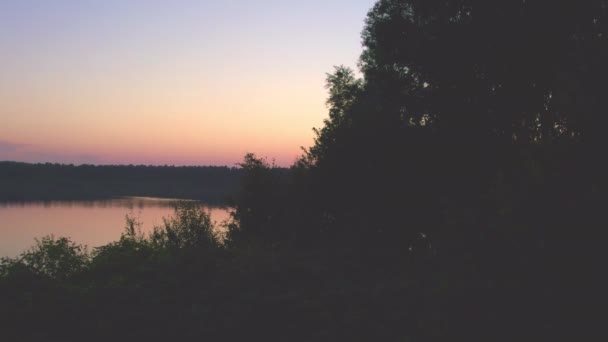 Coucher de soleil spectaculaire et coloré au-dessus d'un lac forestier, prise de vue aérienne sur un drone — Video