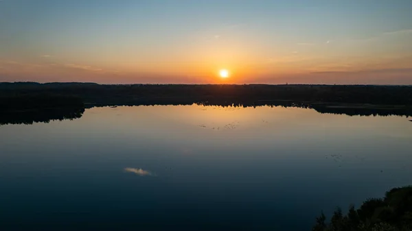 Mooie, kleurrijke lucht boven een meer bij zonsondergang. Vreedzame scène, niemand in zicht. — Stockfoto