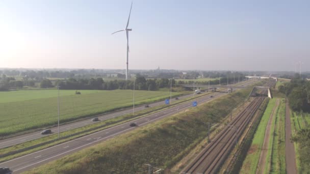 Blick aus der Luft auf Autos, die im Sommer in Belgien, Europa, auf einer Autobahn neben einer Eisenbahn fahren. Luftaufnahme mit Drohne. — Stockvideo
