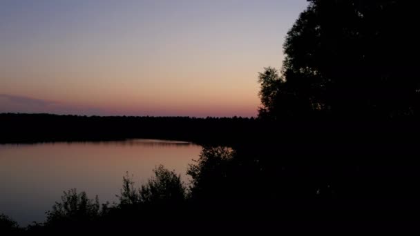 森の湖の上の田舎の劇的でカラフルな日没のフライト、ドローンで空中撮影 — ストック動画